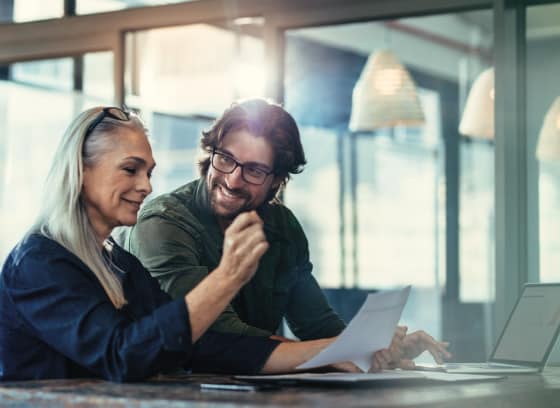 Two co-workers smiling in an office